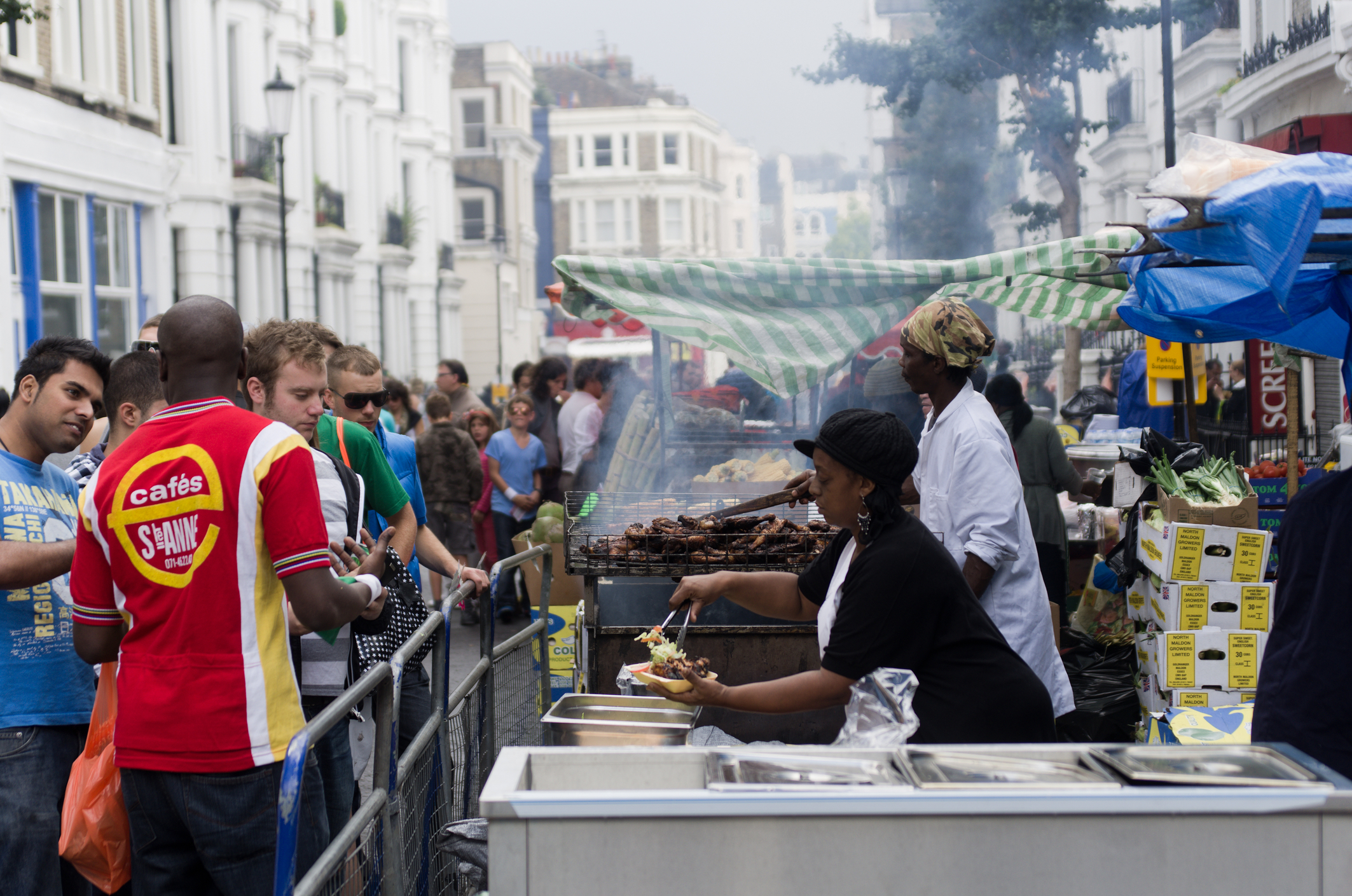 Oameni bucurându-se în Londra de mâncare festivă stradală, în timpul carnavalului Notting Hill. Sursă foto: Dreamstime