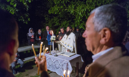 Preot și enoriasi în noaptea Învierii la lumina sfântă