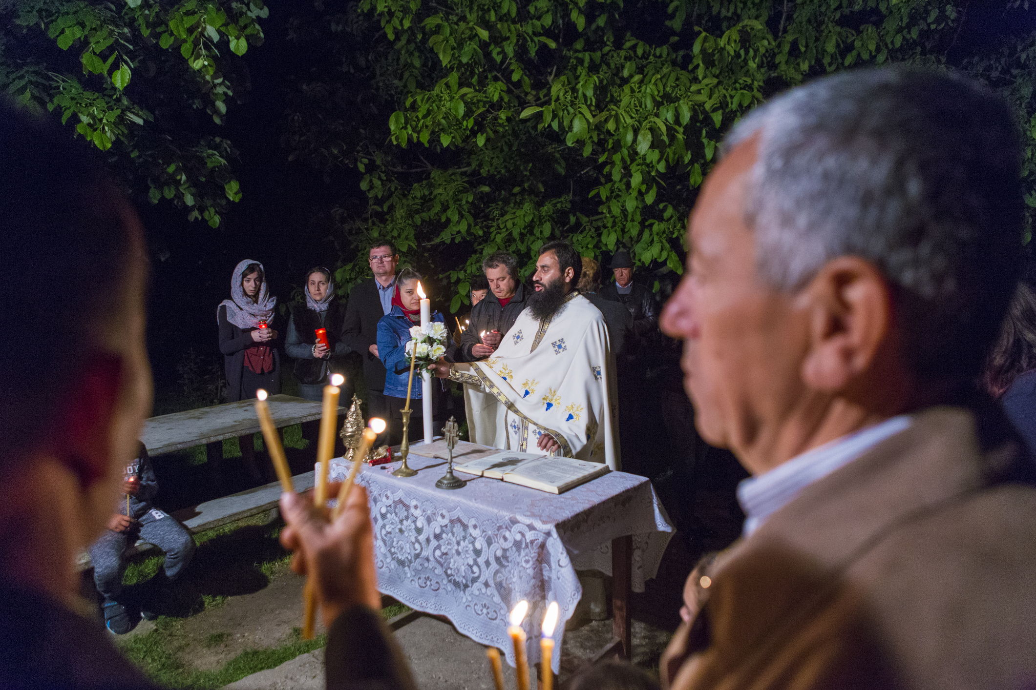 Preot și enoriasi în noaptea Învierii la lumina sfântă